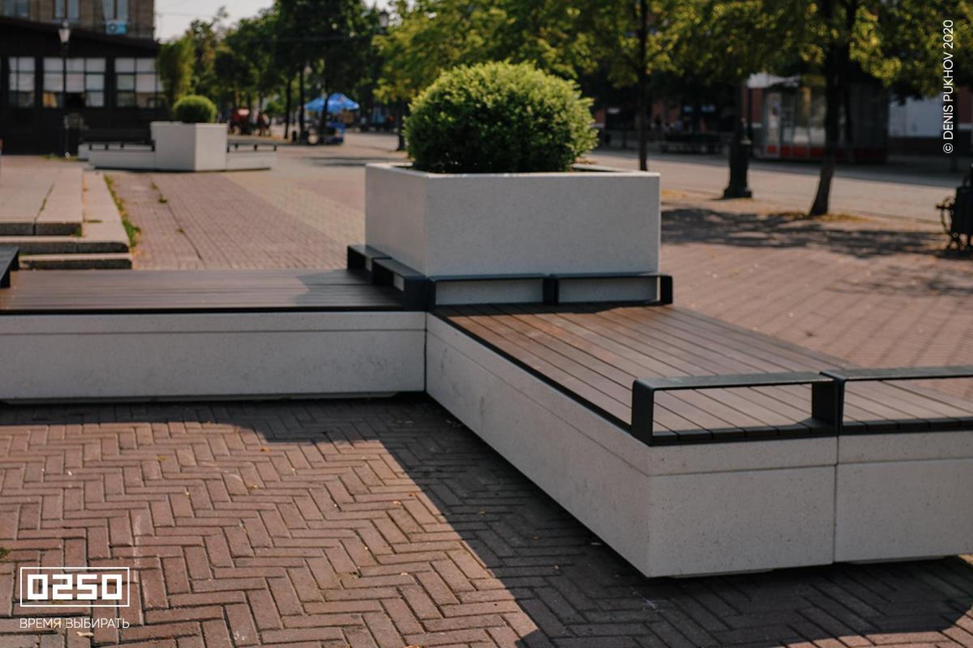 Бетонная скамейка  на подпорной стенке с подлокотниками цвет Белый кварц СМП.БК.НГ3.БК.ТБ от производителя 0250 Фото Двойная Бетонная скамейка на подпорной стенке белого цвета с большим вазоном в сквере на бульваре Челябинск