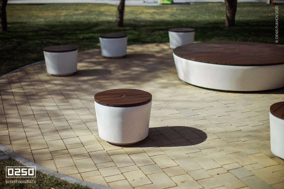 Фото: Больщая бетонная скамейка в окруженни маленьких круглых скамеек